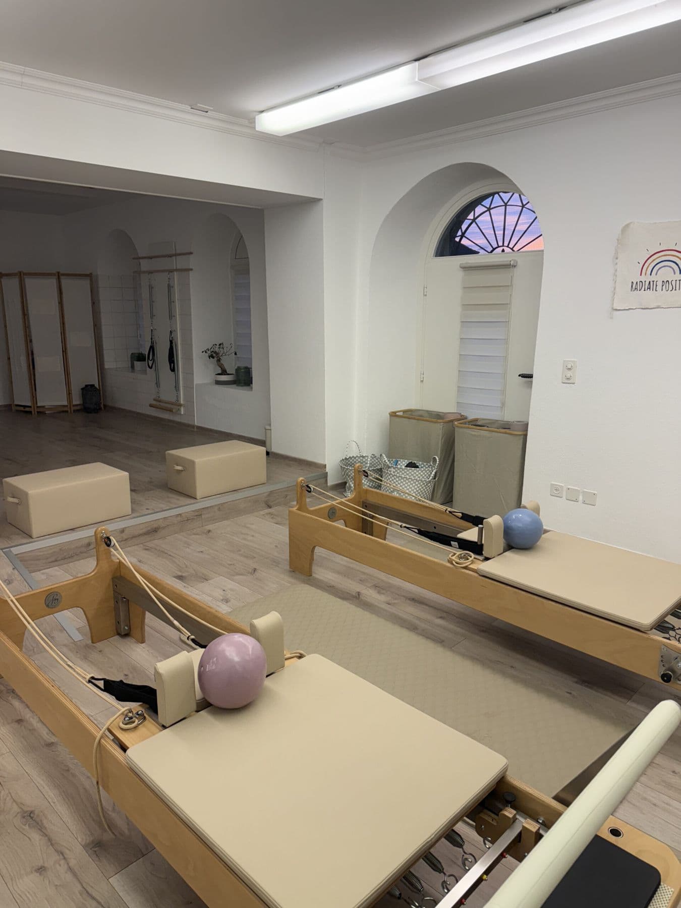 Reformer con la palla rosa e il quadro Radiate Positivity